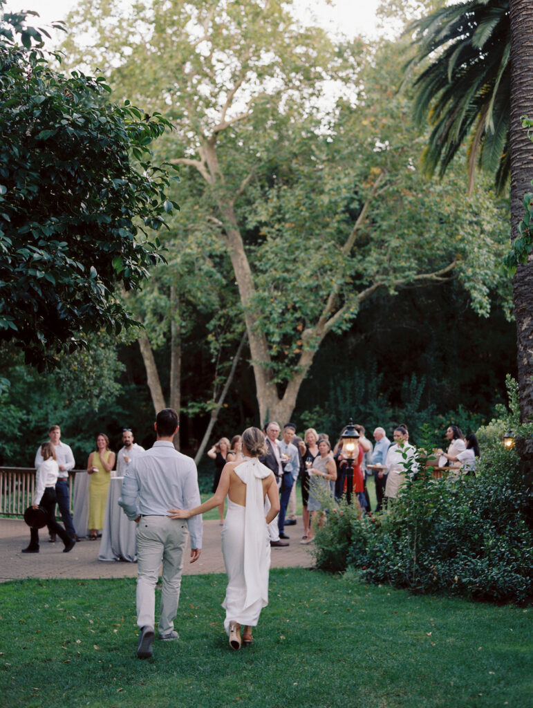 couple walking to cocktail hour with guests cheering. 