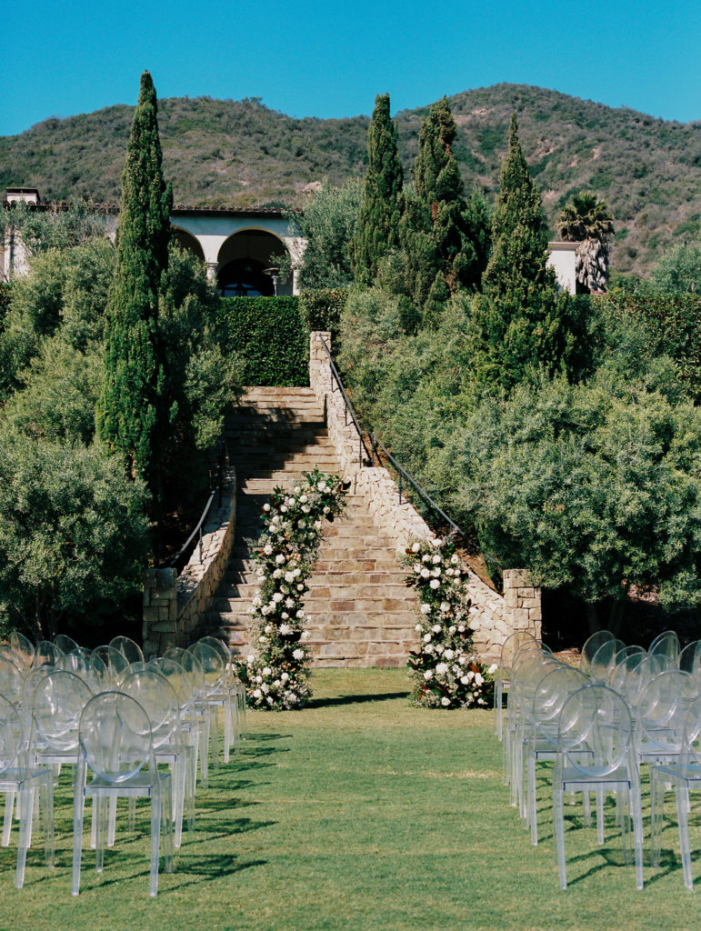 ceremony site with clear chairs and arch 
