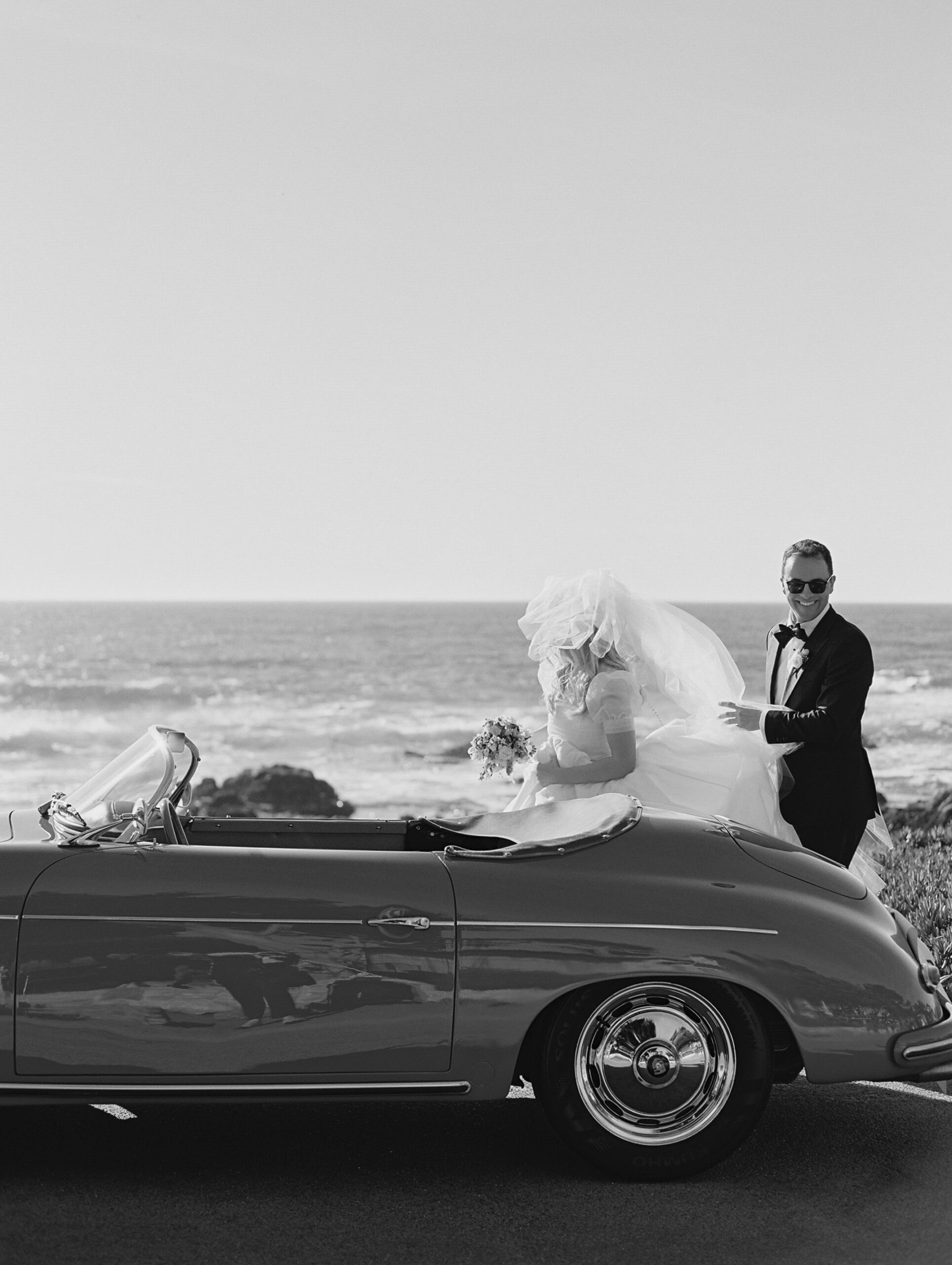 bride with veil blowing in the wind next to the coast in Carmel by the sea 