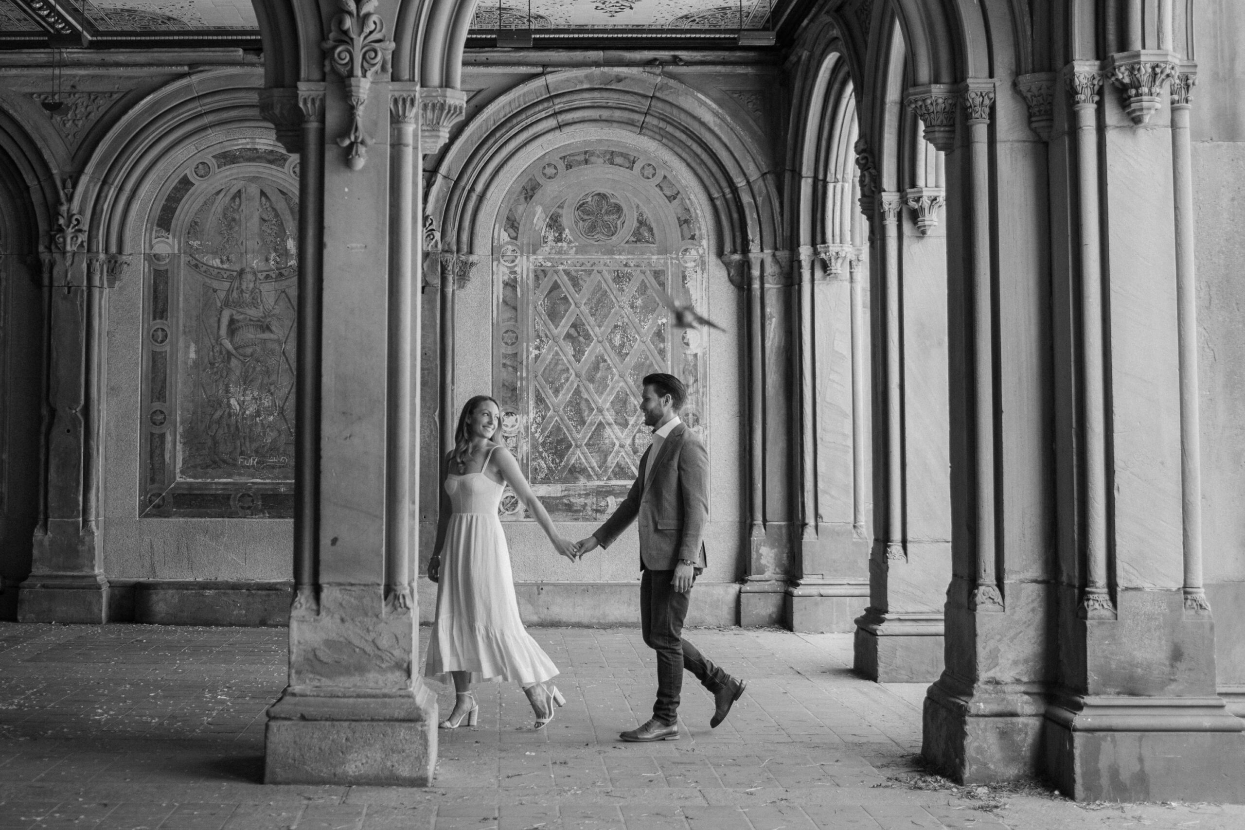 couple walking at Bethesda fountain in black and white
